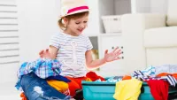 Little girl packing suitcase min
