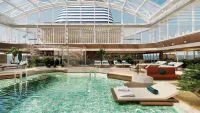 The indoor pool, with its retractable roof, allows swimming and relaxation whatever the weather. Credit: Explora Journeys