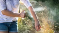 Woman applying insect repellant