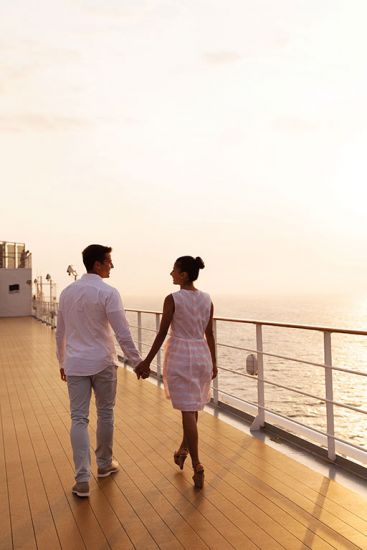 Coupling walking hand in hand on a ship deck on a cruise