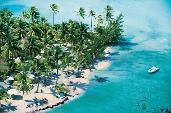 Ariel view of Motu Mahana island, owned by Paul Gauguin cruises, with sea, sand and palm trees