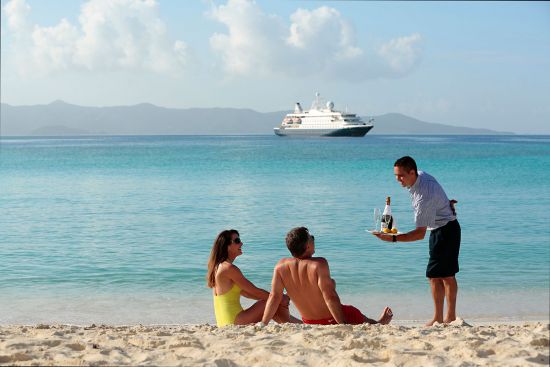 Waiter on a beach offering drinks to cruise passengers in the Caribbean