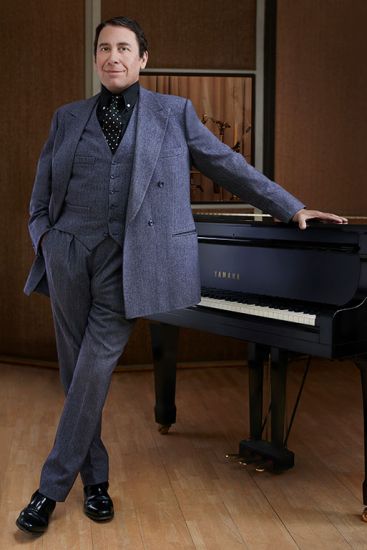 Jools Holland standing by the piano, celebrity interview